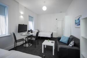 a living room with a couch and a table at BARTON BEACHSIDE APARTMENTS - Free Parking, Modern Chic, Central Beach Location, Some Sea Views - Families Couples or Over 23 years in Blackpool