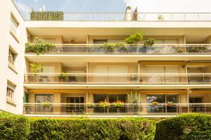 ブローニュ・ビヤンクールにあるAppartement standing avec 2 chambres et balconの植物が植わるアパートメントビル