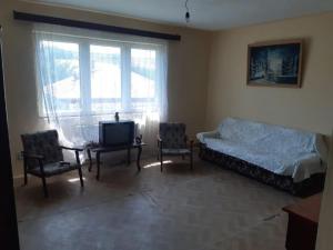 a bedroom with a bed and two chairs and a tv at Vila Codrin in Iaşi