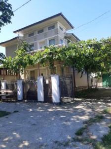 ein Haus mit einem Zaun vor einem Gebäude in der Unterkunft Vila Codrin in Iaşi