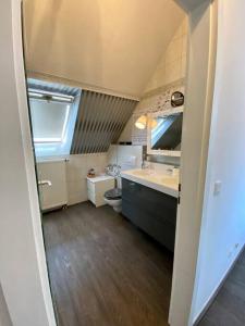 La petite salle de bains est pourvue d'un lavabo et de toilettes. dans l'établissement Light flow stylish attic house. m. balcony, à Rastatt
