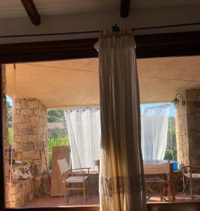 a curtain in a room with a table and chairs at Villa Stella in Costa Paradiso