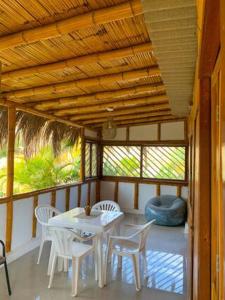 a porch with a white table and chairs on a porch at Fundo El Cortarrama in Talara