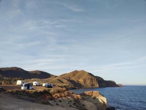 una vista del océano con montañas en el fondo en CORTIJO DEL LUCERO, FERNAN PEREZ en Almería