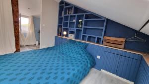 a blue bedroom with a bed with a blue wall at Duplex cosy dans la rue des caves à vin in Saumur