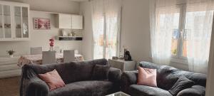 a living room with two couches and a table at Cozy and sunny penthouse Fira BCN in Hospitalet de Llobregat +20 photos