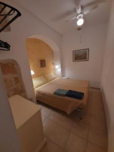 1 dormitorio con 1 cama en una habitación pequeña en Borgo Antico, en Monopoli