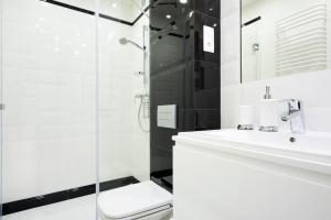 y baño con lavabo y ducha. en Apartament Tenczyńska, en Cracovia