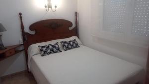 a bed with a wooden headboard and two pillows on it at Arel in Riumar