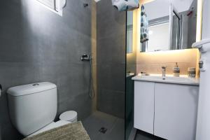 伏罗拉Guest House Narta的带淋浴、马桶和水槽的浴室