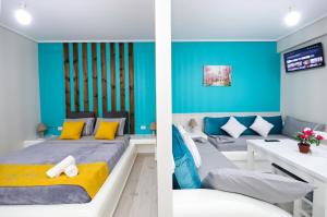 Schlafzimmer mit blauen Wänden und einem Bett mit gelben Kissen in der Unterkunft Guest House Narta in Vlorë