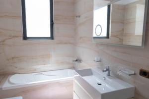 a white bathroom with a sink and a mirror at Luxury Lungomare apartament in Vlorë +9 photos