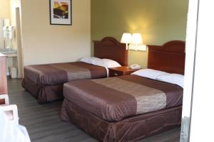 a hotel room with two beds and a table at Woodstream Inn in Hogansville