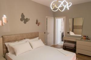 a bedroom with a white bed and a mirror at Luxury Lungomare apartament in Vlorë