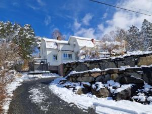 a white house with a stone wall in the snow at Studio 11 in Surte