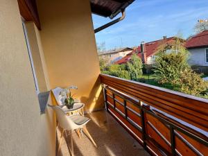 einen Balkon mit zwei weißen Stühlen und einem Fenster in der Unterkunft Hiša Naomi Sofia in Bled