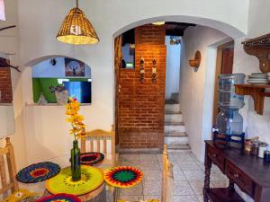 a dining room with a table and a brick wall at El Castillo de Panajachel 6ppl in Panajachel