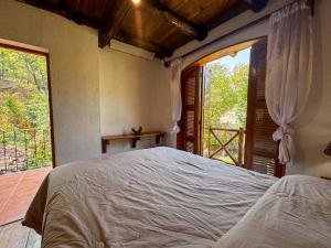 a bedroom with a bed and a large window at El Castillo de Panajachel 6ppl in Panajachel