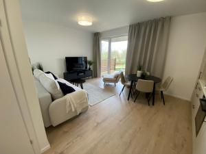 a living room with a white couch and a table at Lazur Seven in Gdańsk