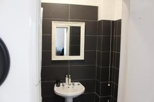 een badkamer met een wastafel en een spiegel bij Flat 5, Westhill in Leeds