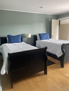 um quarto com 2 camas e almofadas azuis em Pacific Rim Guest Lodge - Adults Only em Ucluelet