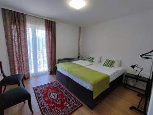 a bedroom with a large bed with a green blanket at FERA Apartments in Sarajevo