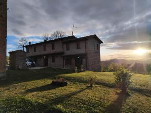 a house on a hill with the sun in the background at B&B del Fernè in Monte Ombraro