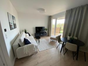 a living room with a white couch and a table at Lazur Seven in Gdańsk