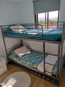a couple of bunk beds in a room with a window at Casa de Ade 