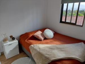 um quarto com uma cama com duas almofadas e uma janela em Casa de Ade 