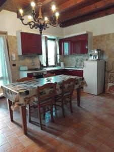 een keuken met een tafel met stoelen en een koelkast bij B&B del Fernè in Monte Ombraro