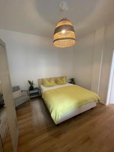 a bedroom with a yellow bed and a chandelier at Loft inmitten der Altstadt in Wangen im Allgäu