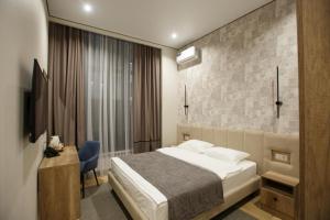 a bedroom with a bed and a desk and a television at Отель Asyl in Astana