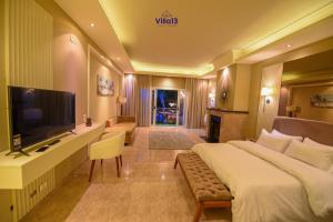 a hotel room with a large bed and a flat screen tv at Villa 13 Luxury suites in Cairo