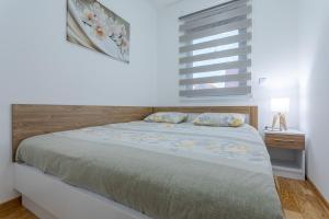 ズラティボールにあるApartman Gavrilov 1のベッドルーム1室(木製ヘッドボードと窓付)