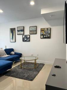 a living room with a blue couch and a table at NEW 3 Story in Homestead- 3/2.5 Balcony & Rooftop in Homestead