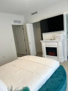 a bedroom with a bed with a fireplace and a tv at NEW 3 Story in Homestead- 3/2.5 Balcony & Rooftop in Homestead