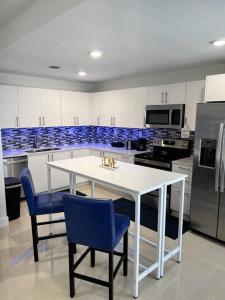 a kitchen with a white table and blue chairs at NEW 3 Story in Homestead- 3/2.5 Balcony & Rooftop in Homestead