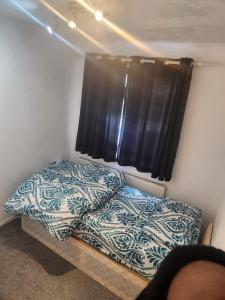 een kleine slaapkamer met een bed en een raam bij Thorogood house in Dagenham