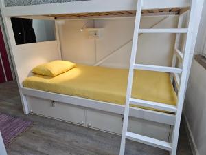 a bunk bed with a yellow pillow on a ladder at SB Alojamento in Amora