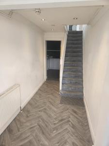 an empty hallway with a staircase in a room at Thorogood house in Dagenham