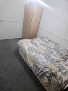 a bed in a room next to a cabinet at Thorogood house in Dagenham