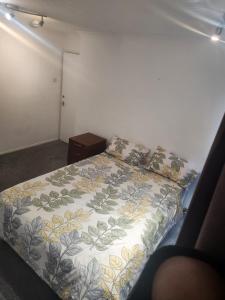 a bedroom with a bed with a floral bedspread at Thorogood house in Dagenham