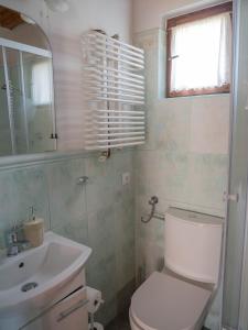 Łazienka z białą toaletą i umywalką w obiekcie Domek myśliwski na wsi w mieście Przemyśl