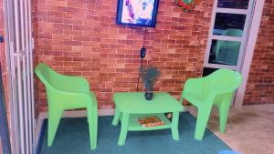 2 chaises et une table à côté d'un mur de briques dans l'établissement La fierté, à Ziguinchor