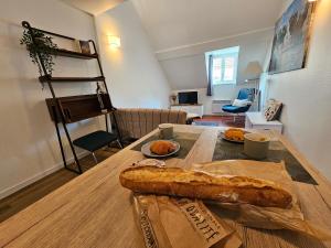 a table with a loaf of bread on top of it at Charmant Duplex au cœur de Vernon proche gare et Giverny in Vernon