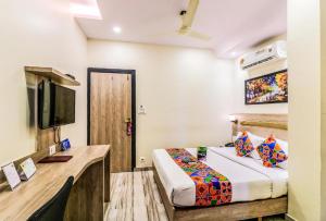 um quarto de hotel com uma cama e uma televisão em New Aksha International By Glitz Hotels em Mumbai