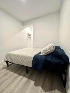 a bedroom with a bed with a blue blanket on it at Appartement 1 chambre - 201 in Montreal