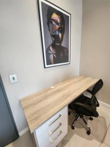 a desk in a room with a picture on the wall at 10th floor, Unit 1008, in The Capital Trilogy, overlooking Sun Time Square in Pretoria