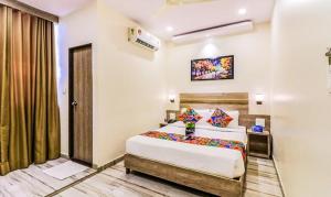um quarto com uma cama grande num quarto em New Aksha International By Glitz Hotels em Mumbai